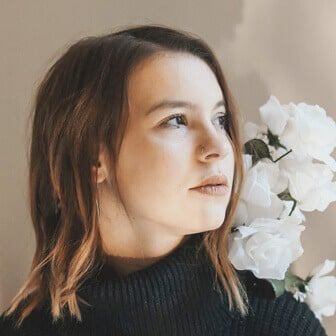 Client testimonial photo of a woman with flowers in the background