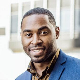 Client testimonial photo of a smiling man in a blue blazer